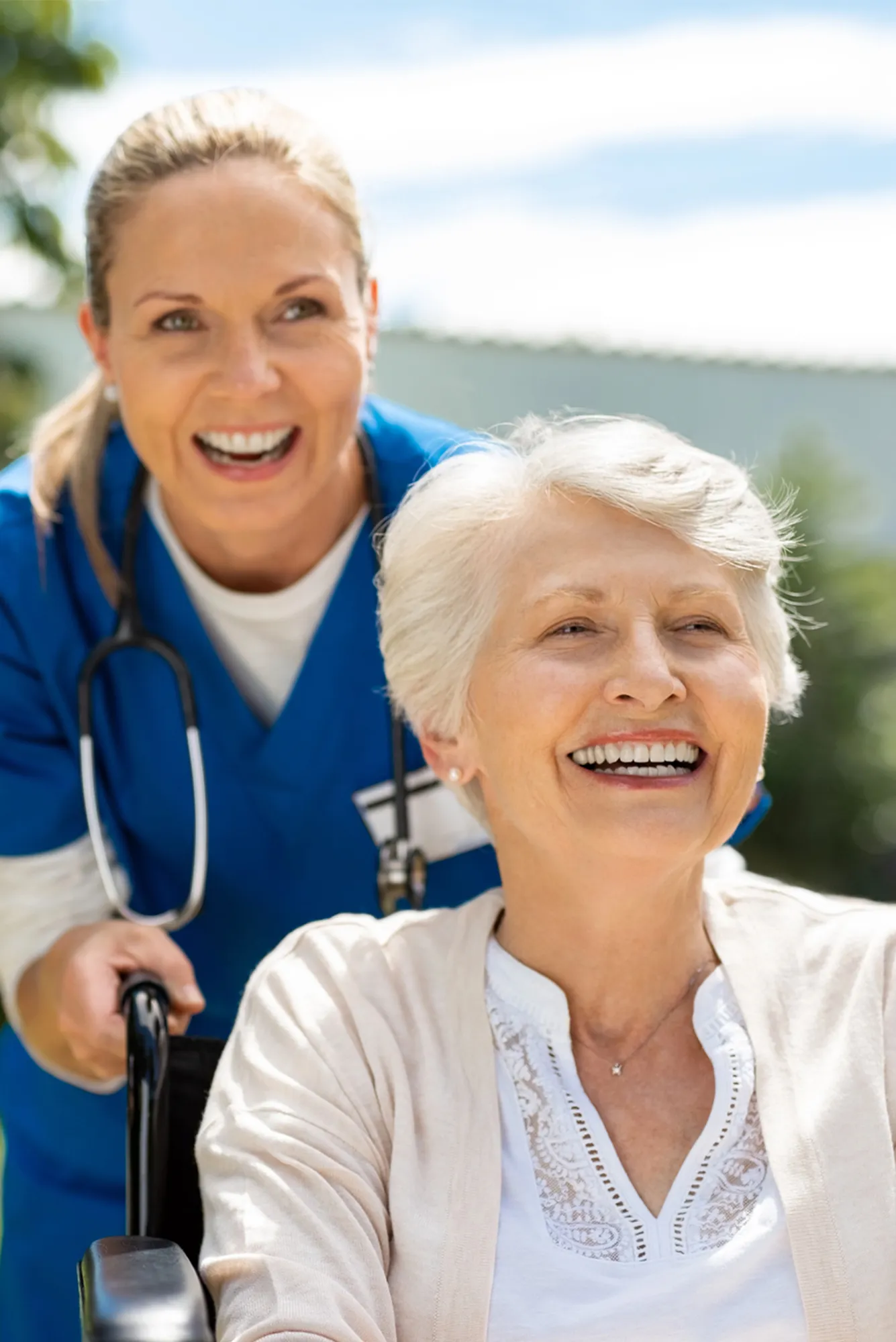 Happy nurse and elderly woman sitting in wheelchair enjoying home health services optimized 1