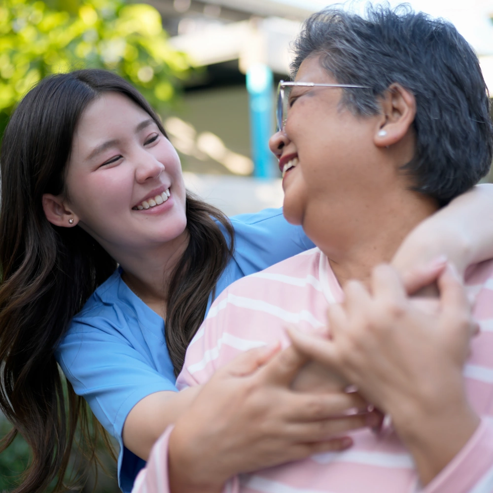 Smiling elderly woman with a caregiver providing support